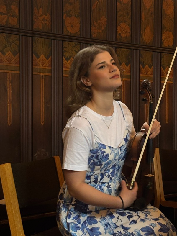 Ariadni sidder med sin violin før en koncert